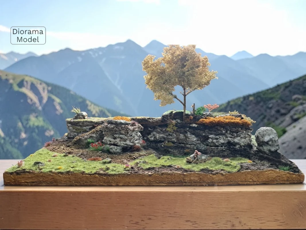 Diorama terreno roccioso realistico con albero autunnale, muschio e vegetazione mista