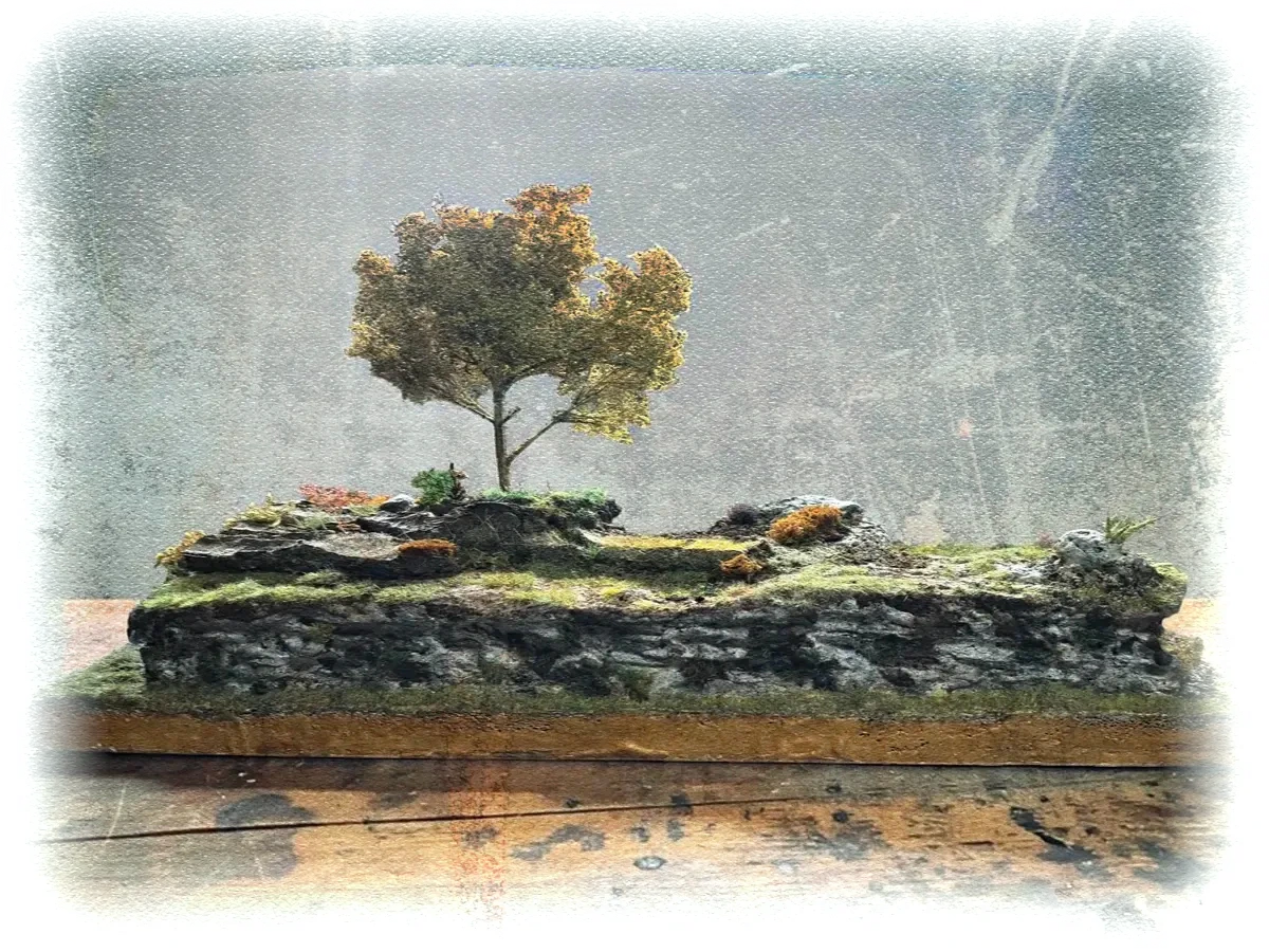 Diorama terreno roccioso realistico con albero autunnale, muschio e vegetazione mista